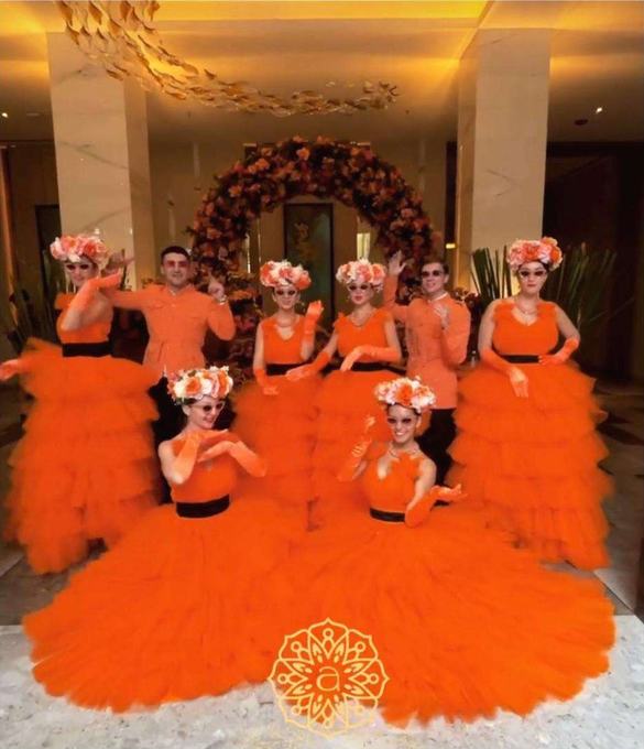 Performers in vivid orange costume