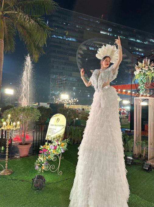 Performer on stilts in white