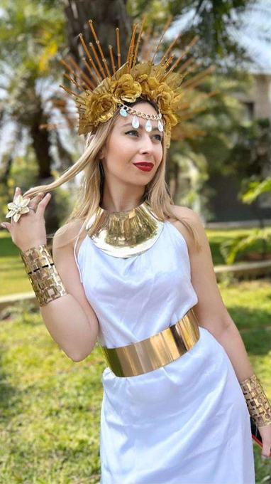 Performer in a white draped gown with a gold collar