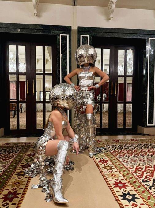 Performers in mirrored disco costume at a doorway
