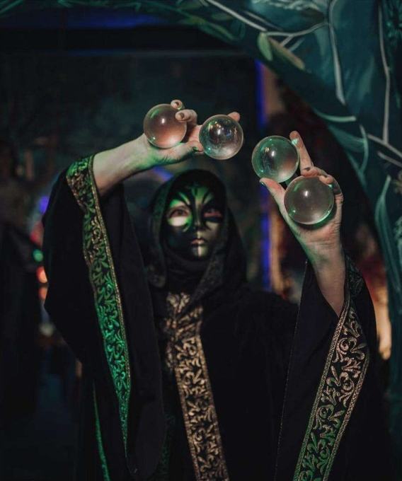 Contact juggler in a green and gold robe