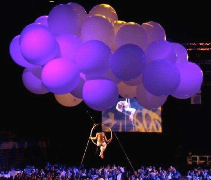 Acrobat suspended from balloons