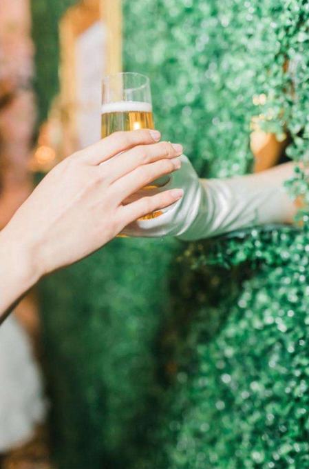 Hand serving a drink through a living wall